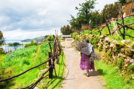 Bolivia - March, 23, 2017: Local woman walking on Island of Sun (Isla del Sol) on Titicaca lake, Boliviaのeditorial素材