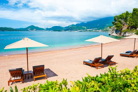 Beautiful beach with chaise lounges in Sveti Stefan near Budva, Montenegro. Luxury resort at Adriatic sea. Famous travel destinationの写真素材