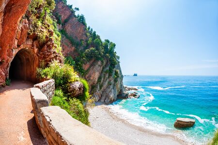 Walkway with tunnel in the cliffs on the beautiful sea coast near Petrovac, Montenegro. Famous travel destinationの写真素材