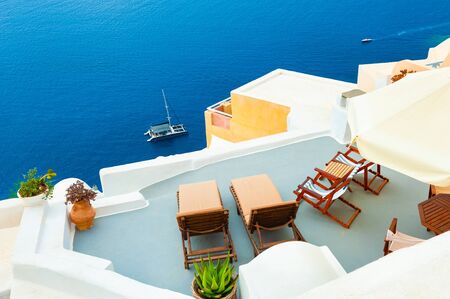 Chaise lounges on the terrace with sea view. Santorini island, Greece. Travel and vacation conceptの写真素材