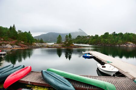 Foggy morning landscape on the coast of fjord in Norway.の写真素材