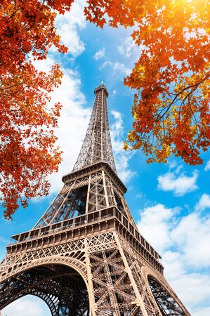 Eiffel Tower against the blue sky and autumn trees in Paris, France. Famous travel destinationの写真素材