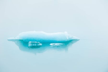 Blue iceberg in Jokulsarlon glacial lagoon in foggy day, southern Iceland.の写真素材