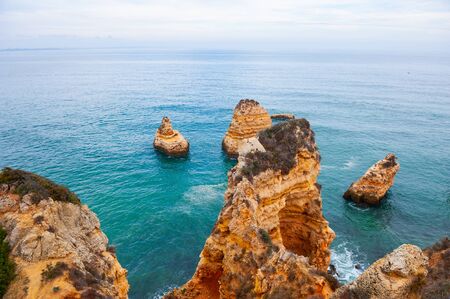 Rocks on the shore of Atlantic ocean in Algarve region in south Portugal. Beautiful summer seascape, famous travel destinationの写真素材