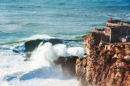 Lighthouse on the coast of Atlantic ocean in Nazare, Portugal. In this place the biggest waves in the world due to the underwater canyonの写真素材