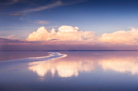 Mirror surface of Salar de Uyuni salt flat at sunset in Bolivia. South America landscapesの写真素材
