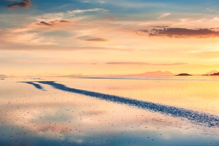 Mirror surface of Salar de Uyuni salt flat at sunset in Bolivia. South America landscapesの写真素材