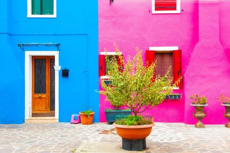 Pink and blue painted facades of the houses. Colorful architecture in Burano island, Venice, Italy.の写真素材