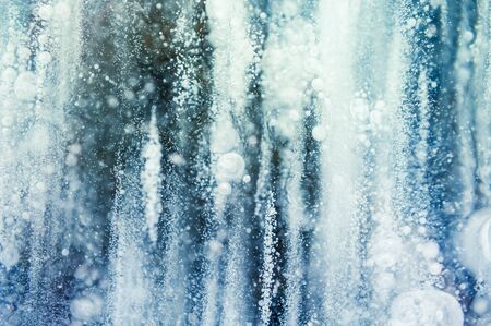 Blue ice with air bubbles in the frozen lake. Macro image. Winter nature backgroundの写真素材