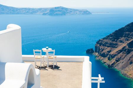 Two chairs on the terrace with sea view. White architecture on Santorini island, Greece. Travel destinations conceptの写真素材