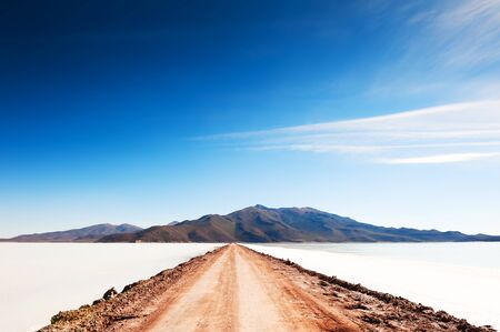 Road to volcano on Salar de Uyuni salt flat in Bolivia. South America landscapes.