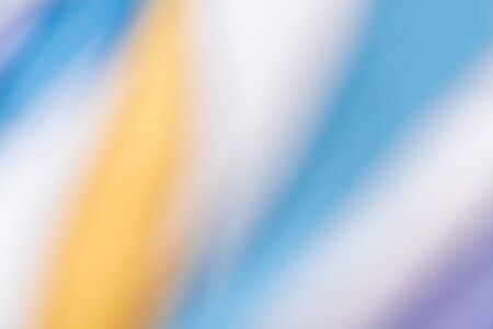 Colorful abstract blurred background. Defocused image of yellow-white-blue textile surfaceの写真素材