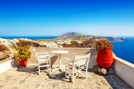 Two chairs with table on the terrace with sea view. Santorini island, Greece. Panoramic view. Travel destinations conceptの写真素材