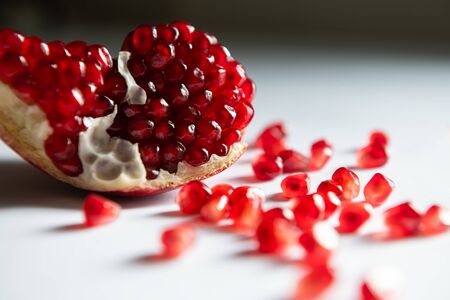 Red ripe pomegranate on the white table close up. Macro image, shallow depth of field. Summer fruits backgroundの写真素材
