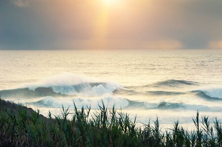 Big waves on the coast of Atlantic ocean at sunset. Selective focus. Nazare, Portugal. Beautiful summer landscape.の写真素材