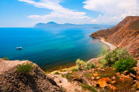 Beautiful bay with turquoise water and mountains. Yacht sailing in the sea. Summer landscape. Eastern coast of Crimea peninsula, Russiaの写真素材