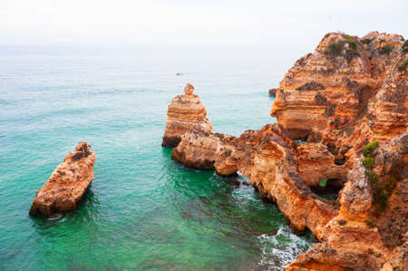 Rocks on the shore of Atlantic ocean in Algarve, Portugal. Beautiful summer seascape, famous travel destinationの写真素材