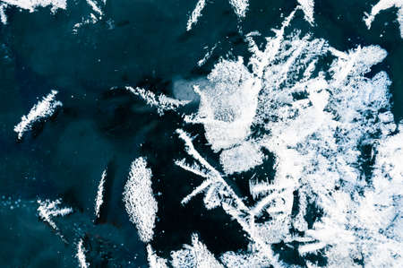 White hoarfrost on the surface of ice on the frozen lake. Macro image. Beautiful winter nature...