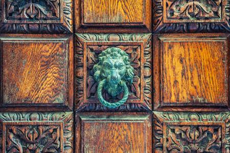 Close up of vintage wooden door with lion-head door knocker. Old architectural backgroundの写真素材