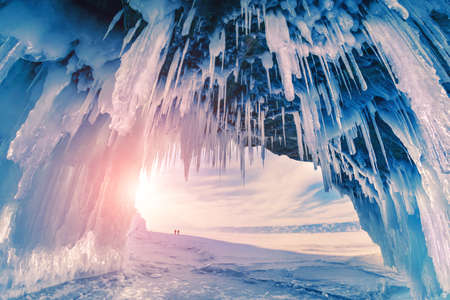 Ice cave on Baikal lake in winter. Blue ice and icicles in the sunset sunlight. Olkhon island, Baikal, Siberia, Russia. Beautiful winter landscape.の写真素材