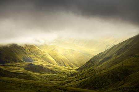 Green summer mountains in misty morning. Clouds over the mountain peaks. Gil-Su valley in North...