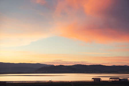Lake in the mountains at sunset. Pink clouds and the blue sky. Beautiful summer landscape. Bashkortostan, Russiaの写真素材