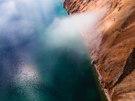 Clouds over the shore of Baikal lake and mountains. Aerial drone view. Baikal lake, Siberia, Russia. Beautiful spring landscapeの写真素材