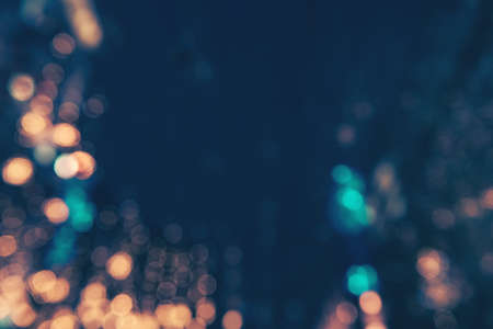 Colorful lights abstract background. Golden and blue defocused lights. Blurred glowing lights on dark blue background.の写真素材