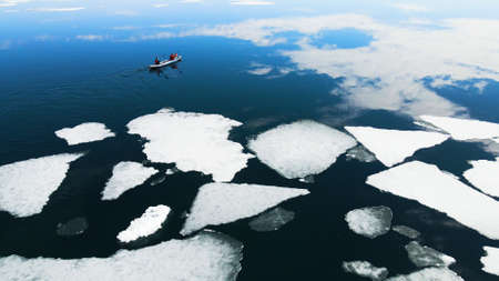 Kayak sailing between ice floes on the lake. Aerial drone view. abstract nature background. Baikal lake, Siberia, Russiaの写真素材