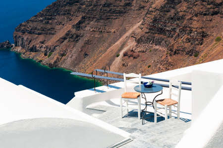 White architecture on Santorini island, Greece. Two chairs on the terrace with sea view. Travel and summer vacations conceptの写真素材