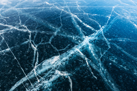 Transparent blue ice with cracks on the lake in winter. Baikal, Russia. Abstract winter nature backgroundの写真素材