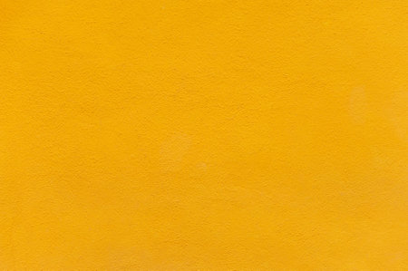 Yellow painted facade of the house. Abstract colorful background. Wall plaster painted with yellow paintの写真素材