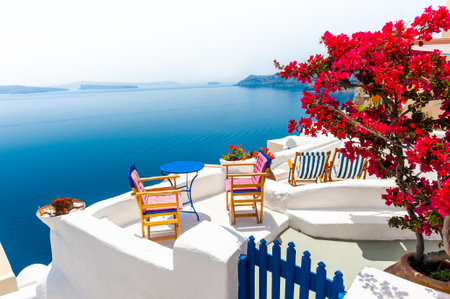 Beautiful terrace with red flowers and sea view. Santorini island, Greece. Travel and summer vacation conceptの写真素材