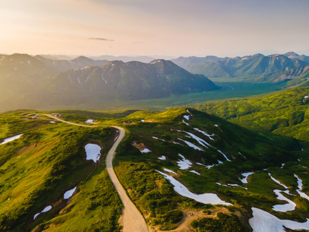 Green mountains with snow at sunset in Vilyuchinsky pass in Kamchatka, Russia. Aerial view. Beautiful summer landscapeの写真素材