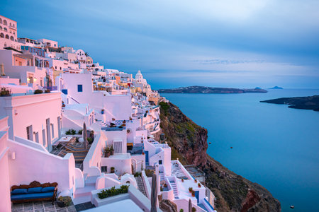 Beautiful sunset at Santorini island, Greece. White architecture in Fira town in pink sunlight. Summer travel and vacationの写真素材