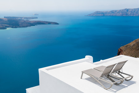 White architecture in Santorini island, Greece. Chaise lounges on the terrace with sea view. Travel and vacation conceptの写真素材