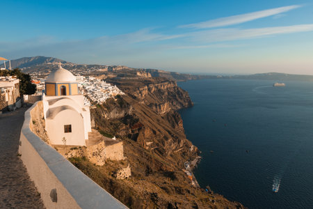 Beautiful sunset in Santorini island, Greece. Old church and sea view in Fira town. Summer travel and vacationの写真素材