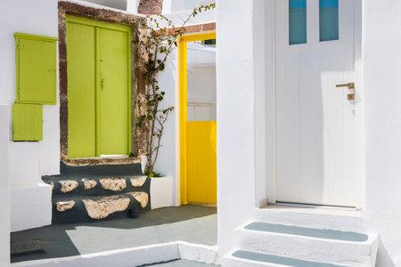 White architecture in Megalochori village, Santorini island, Greece. Colorful doors in cozy courtyardの写真素材