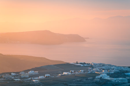 Pink foggy sunset at Santorini island, Greece. View of the sea and islands. Beautiful summer seascape. Famous travel destinationの写真素材