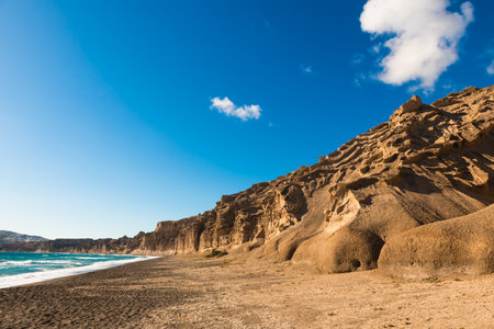 Volcanic cliffs on Vlichada beach, Santorini island, Greece. View of the sea coast at sunny day. Famous travel destinationの写真素材