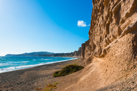 Volcanic cliffs on Vlichada beach, Santorini island, Greece. View of the sea coast at sunny day. Famous travel destinationの写真素材