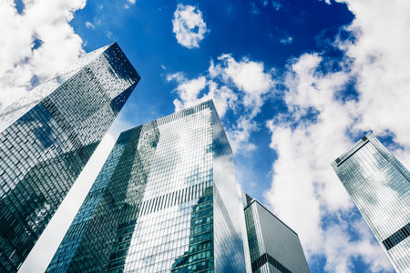 Modern glass skyscrapers against the blue sky with white clouds. Bottom up view. Moscow city, Russia.の写真素材