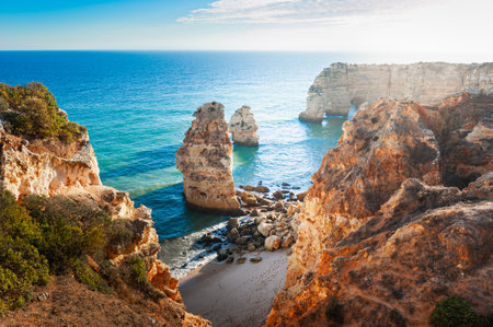 Rocks on the shore of Atlantic ocean in Algarve, Portugal. Beautiful summer landscape at sunsetの写真素材