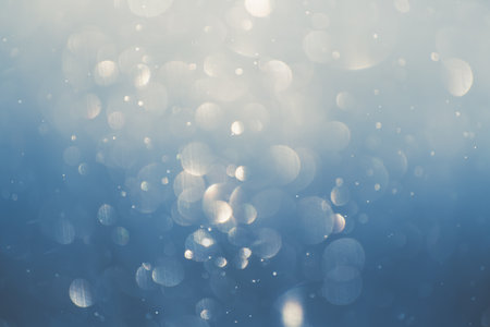 Glowing bokeh abstract background.. Blurred snowflakes in winter forest. Snowflakes spin and glow in the air.の写真素材