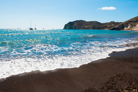 Red beach in Santorini island, Greece. Black volcanic sand and the blue sea. Summer seascape at sunny dayの写真素材