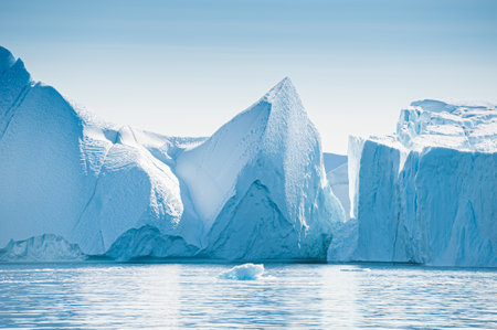 Big icebergs in Atlantic ocean, Ilulissat icefjord, western Greenland. Blue sea and the blue sky at sunriseの写真素材