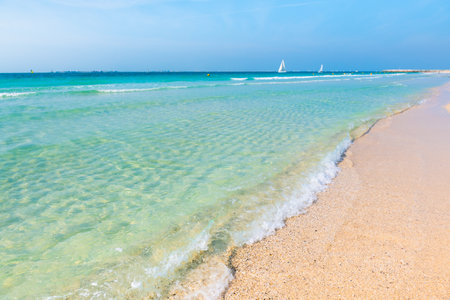 Beautiful beach with white sand and turquoise clear water. White yachts in the sea. Persian Gulf in Dubai, United Arab Emirates.の写真素材
