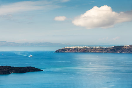 Santorini island, Greece. Blue sea and the blue sky with white clouds. Beautiful summer seascape.