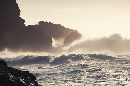 Big ocean waves crashing on the rocks in Nazare, Portugal. Beautiful beach of Atlantic ocean at...