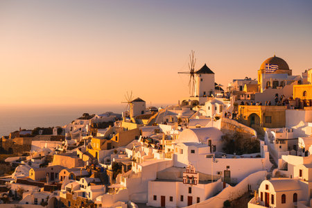 Beautiful sunset at Santorini island, Greece. White architecture and famous windmills in Oia town. Famous travel destinationの写真素材